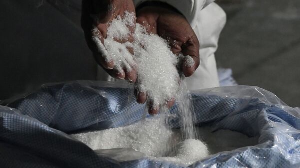 Рабочий осматривает сахар, расфасованный на заводе. Архивное фото - Sputnik Кыргызстан
