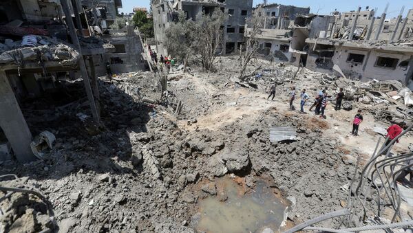 На месте разрушенных домов после израильских авиационных и артиллерийских ударов в северной части сектора Газа. 14 мая 2021 года - Sputnik Кыргызстан