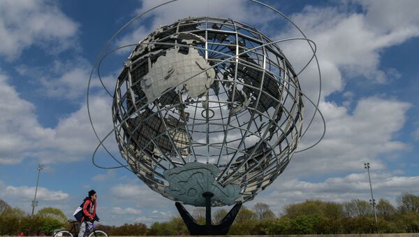 Мальчик проезжает на велосипеде мимо сферического изображения Земли в Нью-Йорке. Архивное фото - Sputnik Кыргызстан