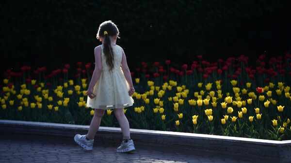 Девочка возле клумбы с тюльпанами. Архивное фото - Sputnik Кыргызстан