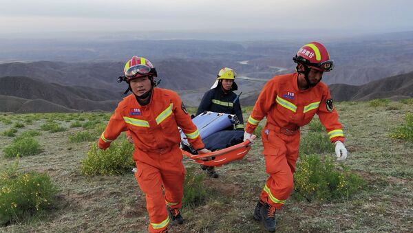 Спасатели несут носилки во время работы на месте, где из-за экстремальных холодов погибли участники ультрамарафонского забега на 100 км в Байине, провинция Ганьсу, Китай. 22 мая 2021 года - Sputnik Кыргызстан
