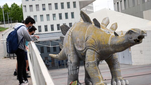 Молодые люди смотрят на статую динозавра, в котором застрял и умер мужчина - Sputnik Кыргызстан