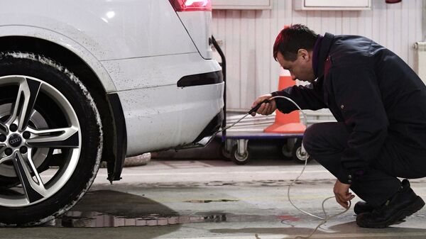 Технический эксперт проводит осмотр автомобиля на СТО. Архивное фото - Sputnik Кыргызстан