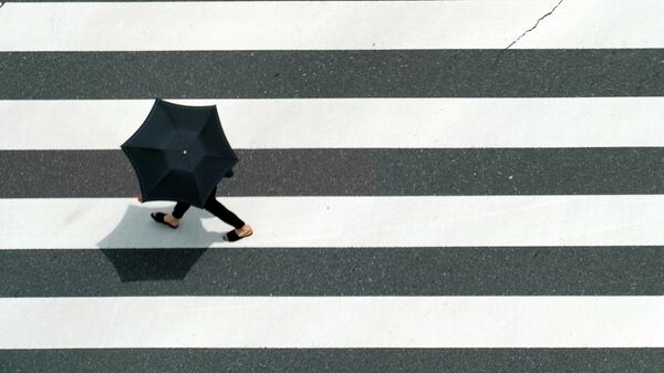 Человек идет под зонтов в жаркую погоду. Архивное фото - Sputnik Кыргызстан