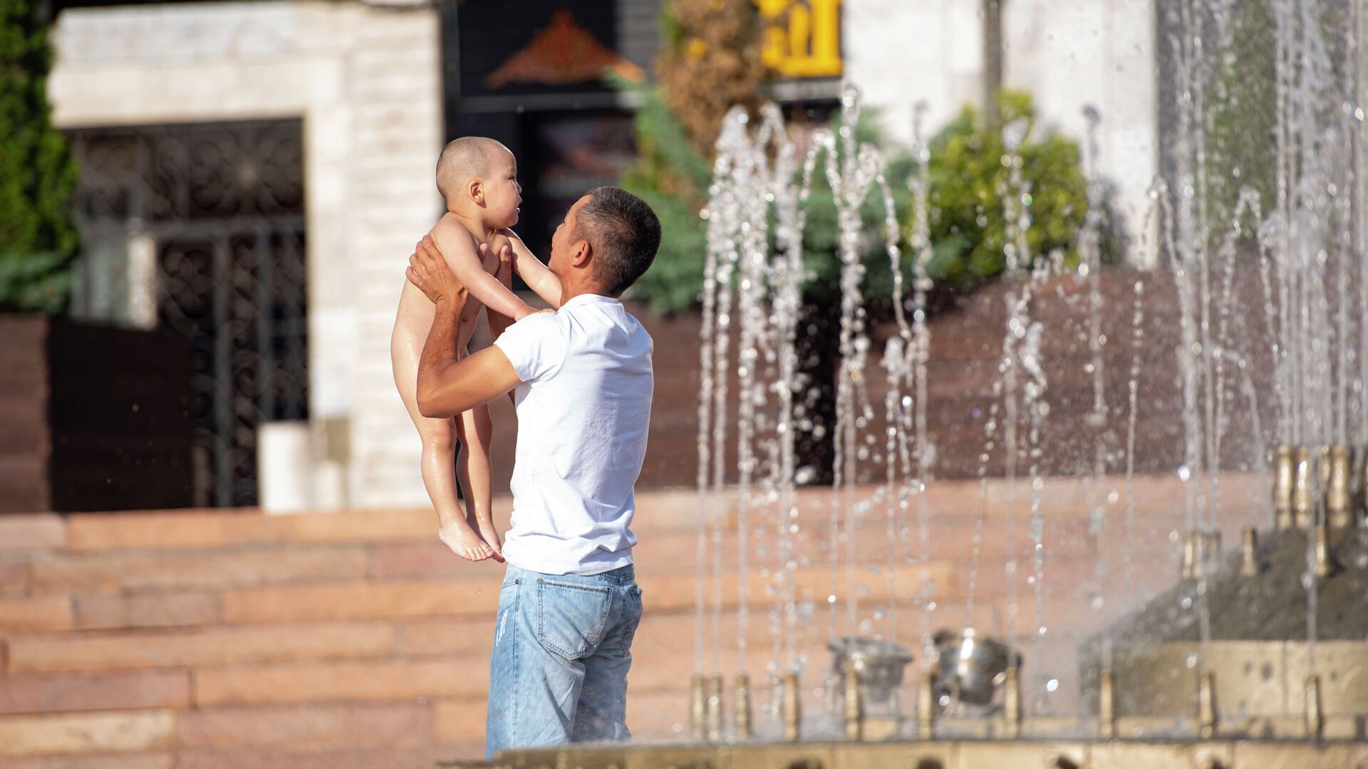 Мужчина купает ребенка в фонтане на площади Ала-Тоо в Бишкеке. Архивное фото - Sputnik Кыргызстан, 1920, 28.06.2022