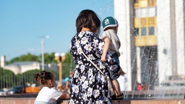 Женщина с ребенком у фонтана на площади Ала-Тоо в Бишкеке. Архивное фото - Sputnik Кыргызстан