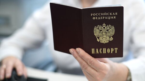 Сотрудник держит в руках паспорт РФ. Архивное фото - Sputnik Кыргызстан