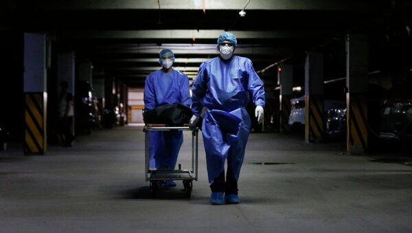 Медицинские работники перевозят в морг тело пациента, умершего от COVID-19. Архивное фото - Sputnik Кыргызстан