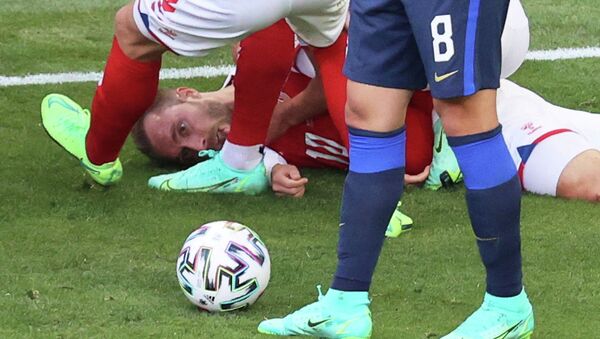 Кристиан Эриксен из Дании лежит на газоне, после того как потерял сознание во время матча с Финляндией в Копенгагене. 12 июня 2021 года  - Sputnik Кыргызстан