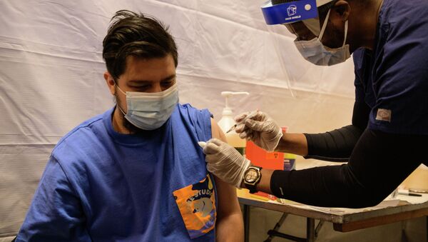 Мужчина получает вакцину от COVID-19 во временном пункте вакцинации в Нью-Йорке. Архивное фото - Sputnik Кыргызстан