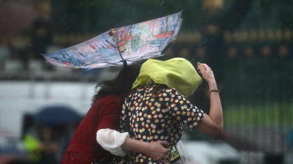 Прохожие под зонтом во время дождя. Архивное фото - Sputnik Кыргызстан