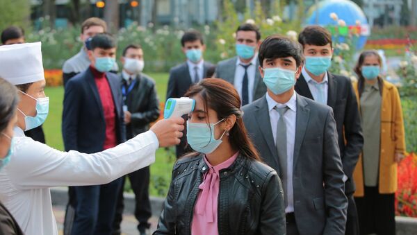 Душанбе шаарында медициналык кызматкерлери кишилердин температурасын өлчөп жатышат. Архив - Sputnik Кыргызстан