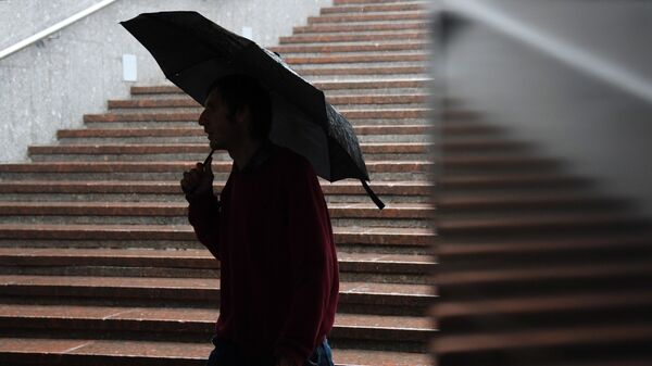 Прохожий с зонтом во время дождя. Архивное фото - Sputnik Кыргызстан