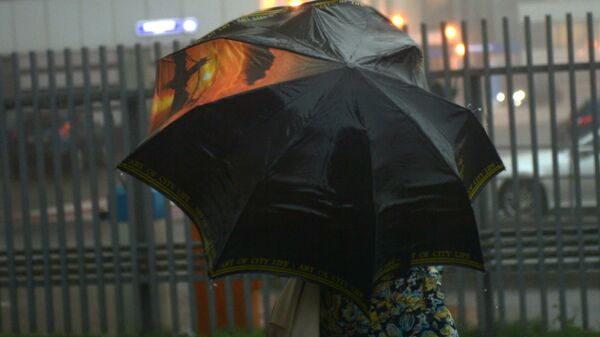 Девушка с зонтом во время ливня. Архивное фото - Sputnik Кыргызстан