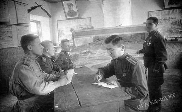 Фронтовики Рузи Азимов (справа) и Акбар Толкомбаев делятся боевым опытом с курсантами в Фрунзенском пехотном училище. 1945 год  - Sputnik Кыргызстан