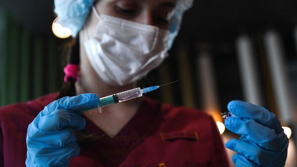 Медициналык кызматкер вакцина менен шприцти кармап турат. Архив - Sputnik Кыргызстан