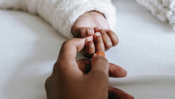 Мать держит за руку новорожденного ребенка. Архивное фото - Sputnik Кыргызстан