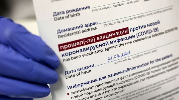 Медицинский работник держит в руках сертификат о вакцинации от коронавируса. Архив - Sputnik Кыргызстан