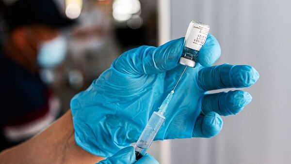 Медицинский сотрудник наполняет шприц вакциной от коронавируса. Архивное фото - Sputnik Кыргызстан