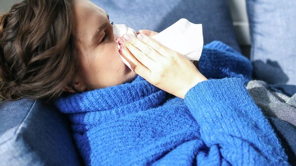 Женщина с симптомами гриппа лежит на диване. Иллюстративное фото - Sputnik Кыргызстан