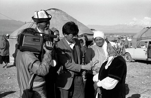 Улуу манасчынын Тоң районунун Ак-Өлөң айылында өткөрүлгөн 100 жылдыгында Карасаевдин кызы журналисттерге интервью берүүдө. 1994-жыл - Sputnik Кыргызстан
