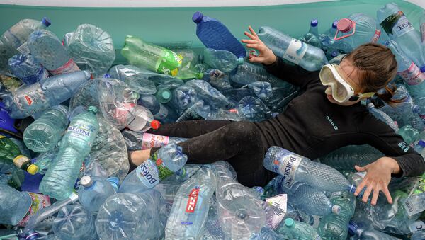 Активист лежит в надувном бассейне, наполненном пластиковыми бутылками во время акции протеста. Архивное фото - Sputnik Кыргызстан