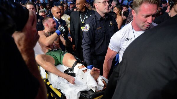 Ирландского бойца UFC  Конора МакГрегора уносят на носилках после боя с американцем Дастином Порье. Архивное фото - Sputnik Кыргызстан