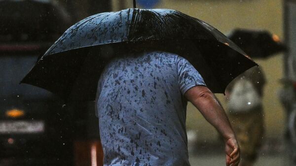 Мужчина идет по улице во время дождя. Архивное фото - Sputnik Кыргызстан