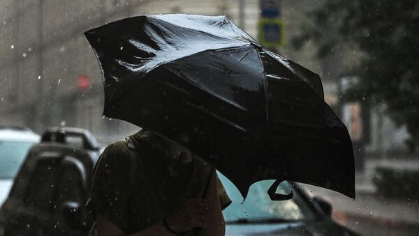 Девушка идет по улице во время дождя. Архивное фото - Sputnik Кыргызстан