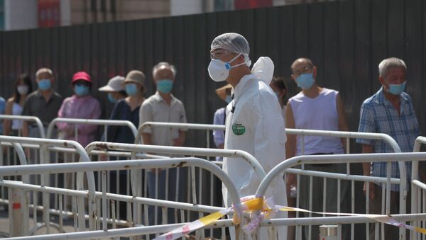 Рабочий в СИЗ наблюдает за людьми, ожидающими очереди на сдачу мазков на COVID-19 в Пекине. Архивное фото - Sputnik Кыргызстан