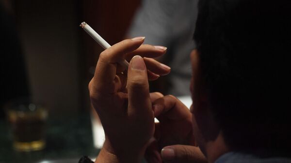 Мужчина курит сигарету в ресторане. Архивное фото - Sputnik Кыргызстан