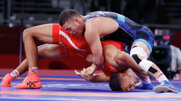 Акжол Махмудов (в синем) из Кыргызстана борется с Ламджедом Маафи из Туниса в весовой категории до 77 кг во время Олимпийских игр 2020 года в Токио. 2 августа 2021 года - Sputnik Кыргызстан