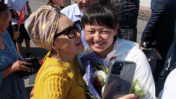 Бронзовая медалистка Олимпийских игр в Токио Мээрим Жуманазарова фотографируется с людьми на церемонии приветствия призеров и участников Олимпийских игр на площади Ала-Тоо в Бишкеке - Sputnik Кыргызстан