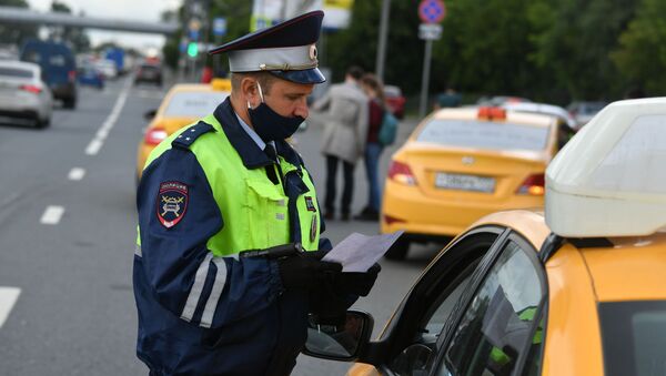 Сотрудник ГИБДД во время рейда в Москве по проверке автомобилей такси на соответствие правилам безопасности перевозок. Архивное фото - Sputnik Кыргызстан