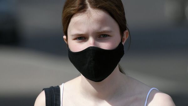 Девушка в защитной маске на улице. Архивное фото - Sputnik Кыргызстан