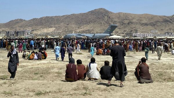 Толпа людей стоят в аэропорту Кабула во время взлета самолета ВВС США - Sputnik Кыргызстан
