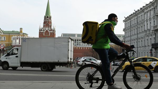 Сотрудник курьерской службы едет на велосипеде по улице в Москве. Архивное фото - Sputnik Кыргызстан