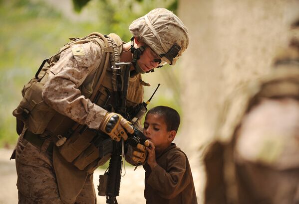 Лейтенант морской пехоты США Мэтью Майнор показывает фотографию на экране цифровой камеры маленькому афганскому мальчику в городе Муса-Кала - Sputnik Кыргызстан