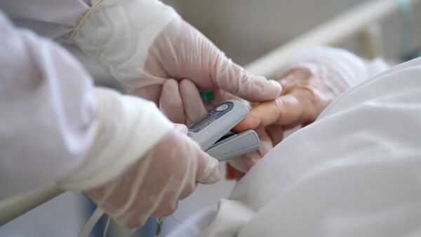 Медицинский работник измеряет уровень кислорода в крови пациенту. Архивное фото - Sputnik Кыргызстан