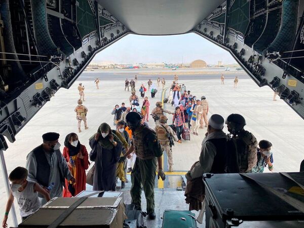 Граждане Испании и афганцы садятся в военный самолет в рамках эвакуации в международном аэропорту Хамида Карзая в Кабуле - Sputnik Кыргызстан