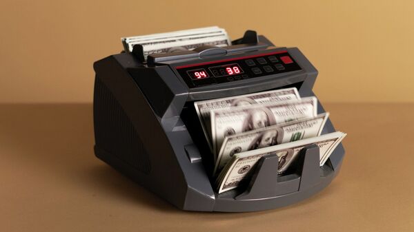 Купюры долларов США в счетной машинке. Иллюстративное фото  - Sputnik Кыргызстан