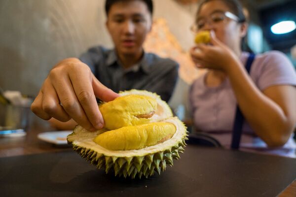 Посетители кафе во время поедания дуриана в Сингапуре  - Sputnik Кыргызстан