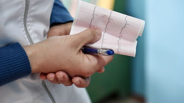 Медицинский работник держит кардиограмму сердца. Архивное фото - Sputnik Кыргызстан