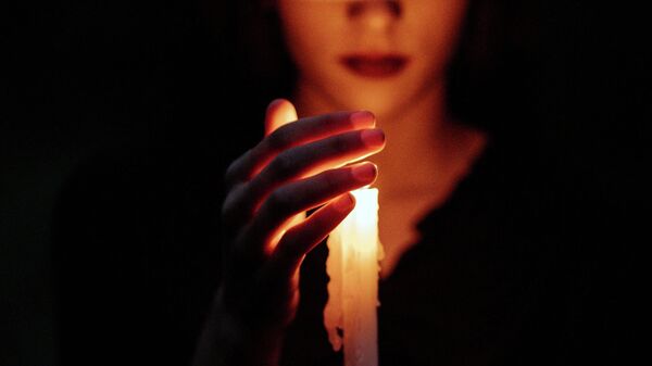 Девушка с зажженной свечой во время отключения света. Иллюстративное фото - Sputnik Кыргызстан
