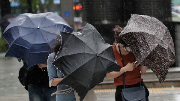 Люди с зонтами во время сильного ветра и дождя. Архивное фото - Sputnik Кыргызстан