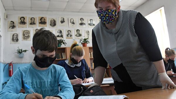 Мугалим окуучунун тапшырмасын текшерип жатат. Архив - Sputnik Кыргызстан