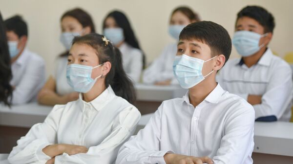 Школьники в медицинских масках на уроке в средней школе. Архивное фото - Sputnik Кыргызстан