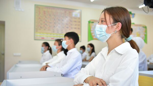 Школьники в медицинских масках на уроке в средней школе. Архивное фото - Sputnik Кыргызстан