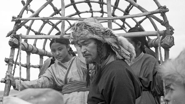 Фотография заслуженного артиста Кыргызстана Токона Дайырбекова и девушек-актрис на заднем фоне была снята в 1994 году в Чуйской области. - Sputnik Кыргызстан