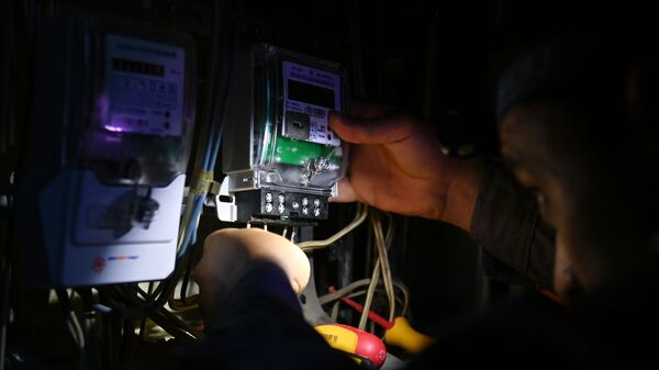 Электрик проводит работы по замене счетчиков. Архивное фото - Sputnik Кыргызстан